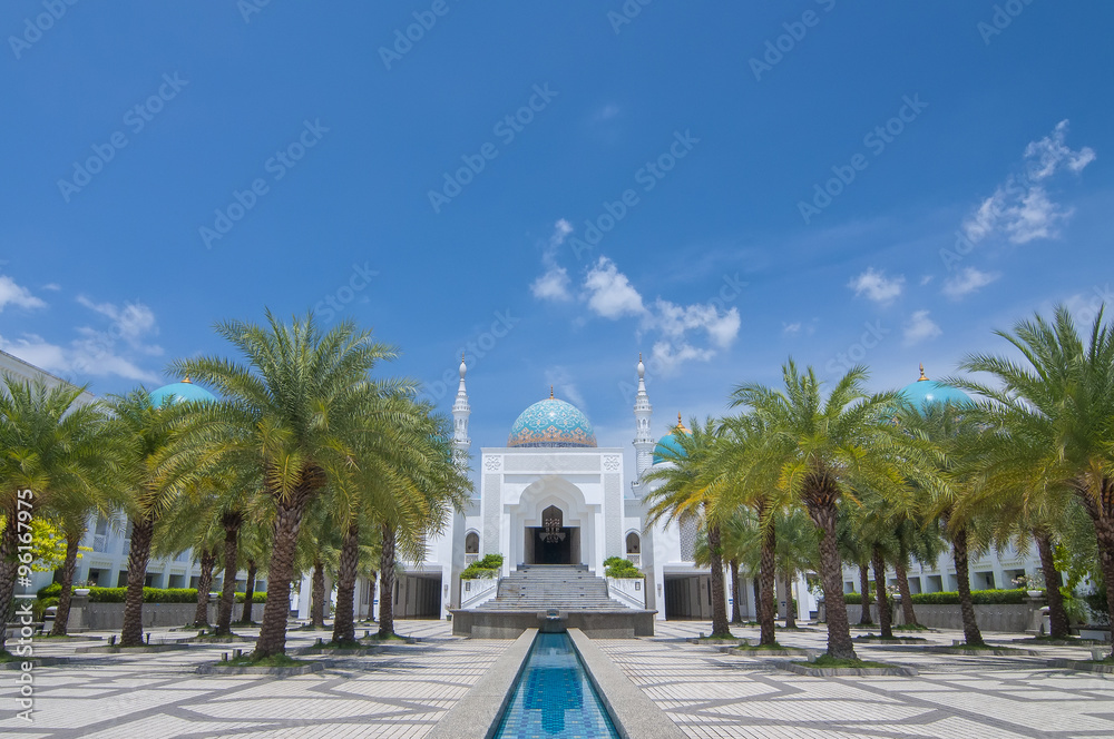 The white of Mosque Albukhary located in Alor Star, state of Kedah, Malaysia with its fountain and squares in the foreground and blue sky with clouds in the background