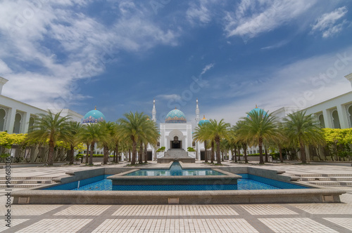 Scenery of Mosque Albukhary located in Alor Star, state of Kedah, Malaysia with its fountain and squares in the foreground and blue sky with clouds in the background.
