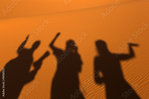 Sillhouette of people in sands on desert Sahara