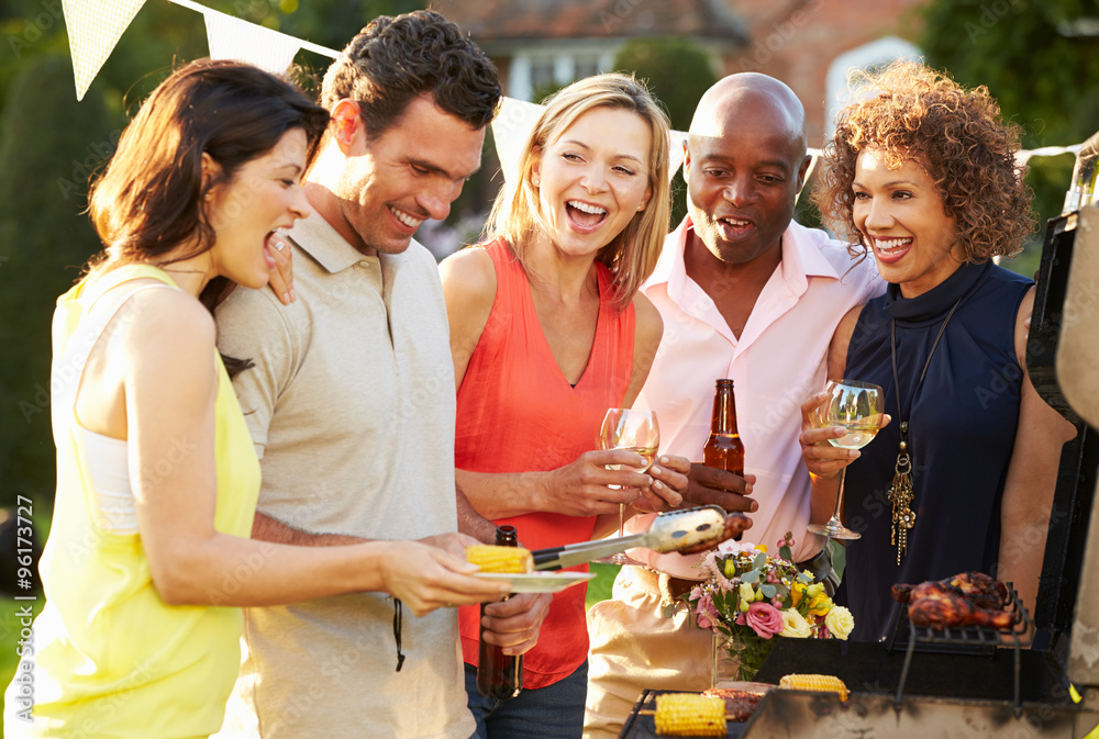 Obraz premium Mature Friends Enjoying Outdoor Summer Barbeque In Garden