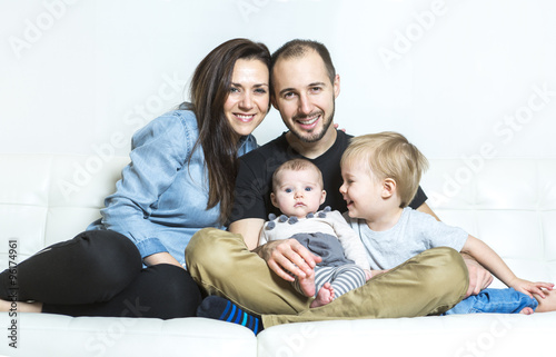 Young happy family with two children at home