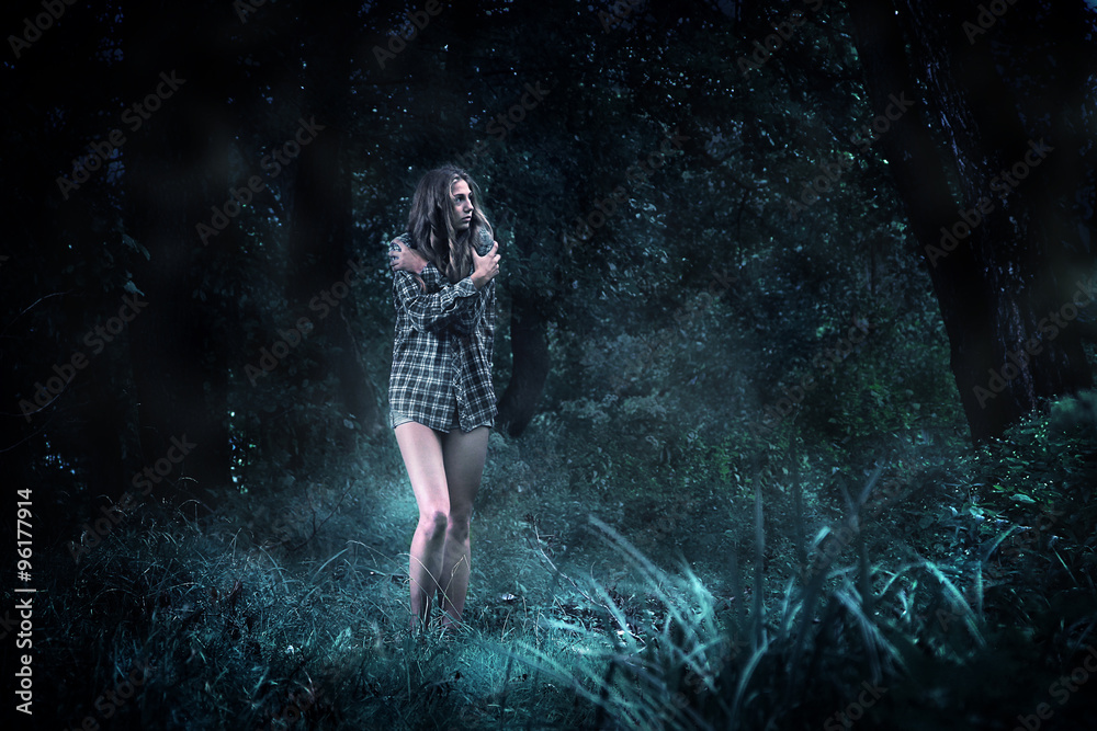 Frightened girl in a dark forest