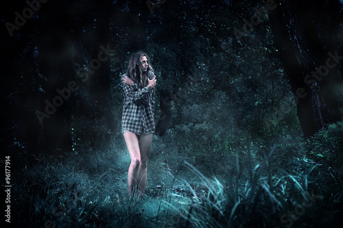 Frightened girl in a dark forest