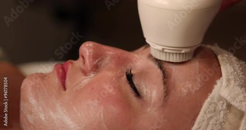 Facial Scrubbing Close Up. camera moves left as client receives exfoliating treatment on face. close up
 photo