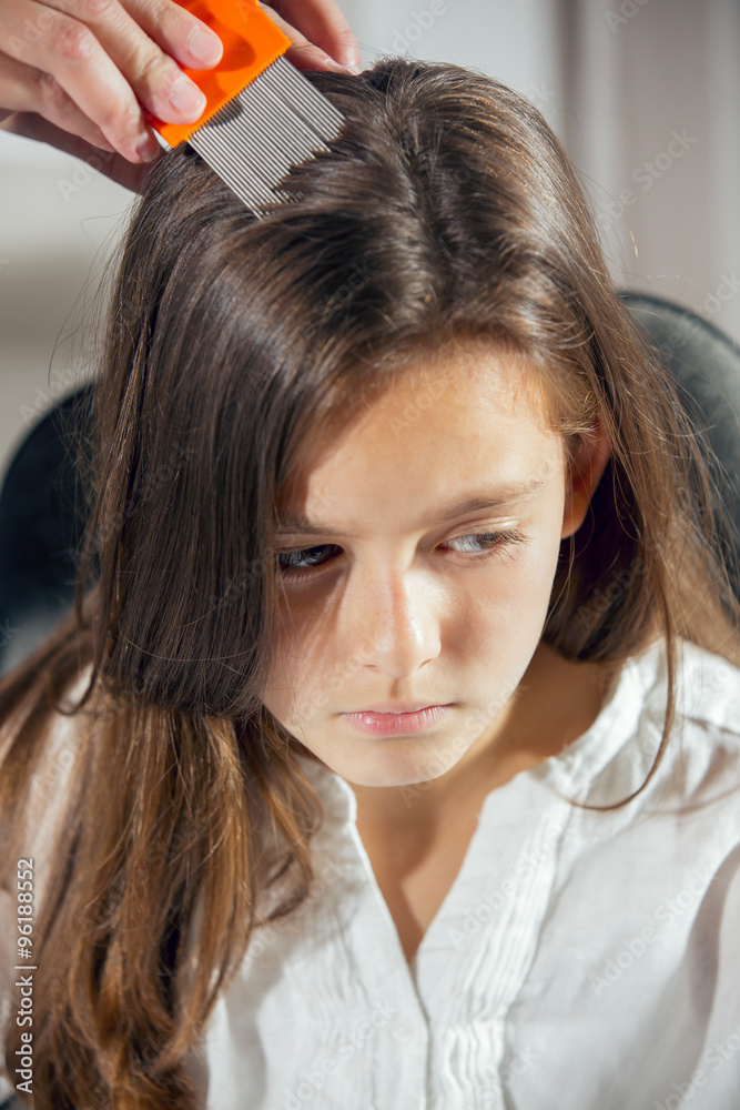 Mother treating daughter's hair against lice. Selective focus Mother treating daughter's hair against lice. Selective focus