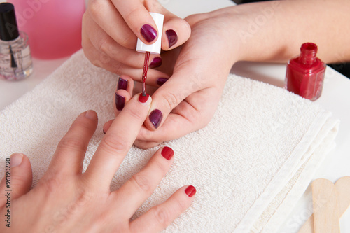 Woman Having Fingernails Painted At Beauty Salon