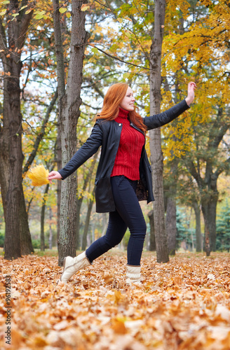 redhead girl run with leaf bouquet in city park, fall season