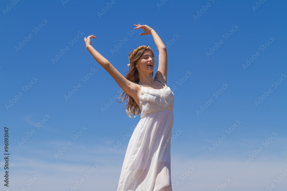 Young brunette in white flimsy dress enjoys the summer sun. Young brunette in white flimsy dress enjoys the summer sun.