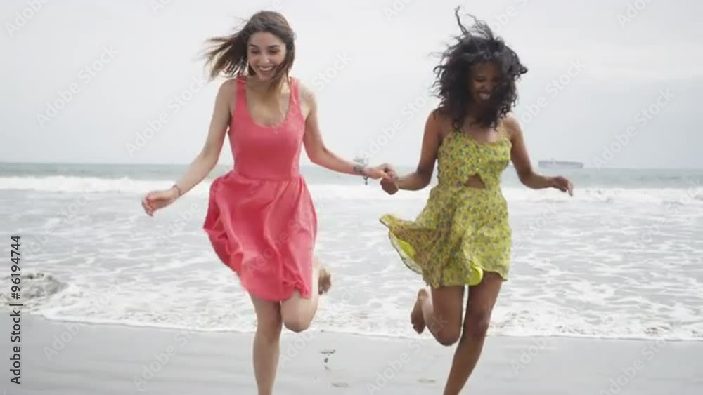 Cute Women runing away from the tide at the beach