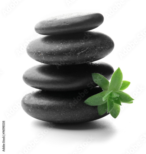 Stack of stones and a green flower  isolated on white. Spa relaxation concept