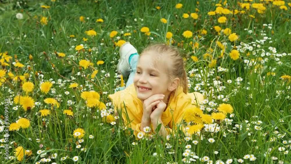Laughing girl lying in the grass and looking at camera Laughing girl lying in the grass and looking at camera