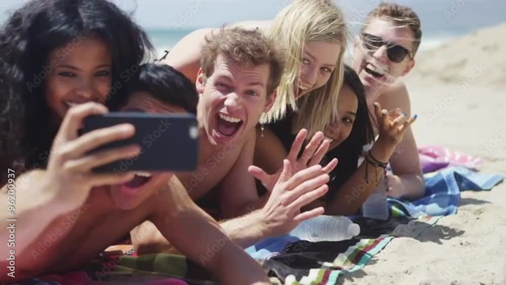 Group of young interracial friends taking selfie on the beach Group of young interracial friends taking selfie on the beach