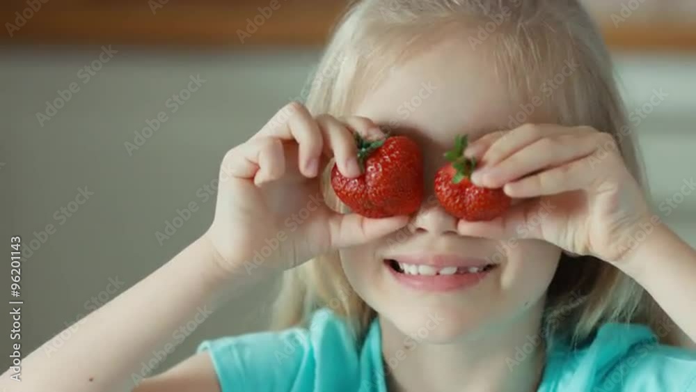 Laughing girl playing with two strawberries. Closeup portrait Laughing girl playing with two strawberries. Closeup portrait
