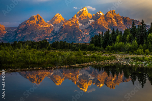 Photo The dramatic colors of the Grand Teton Mountains reflecting in the water on a clear summer morning