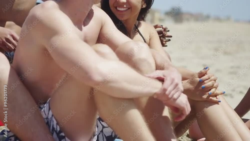 Young adult group of multi-ethnic friends relaxing at the beach