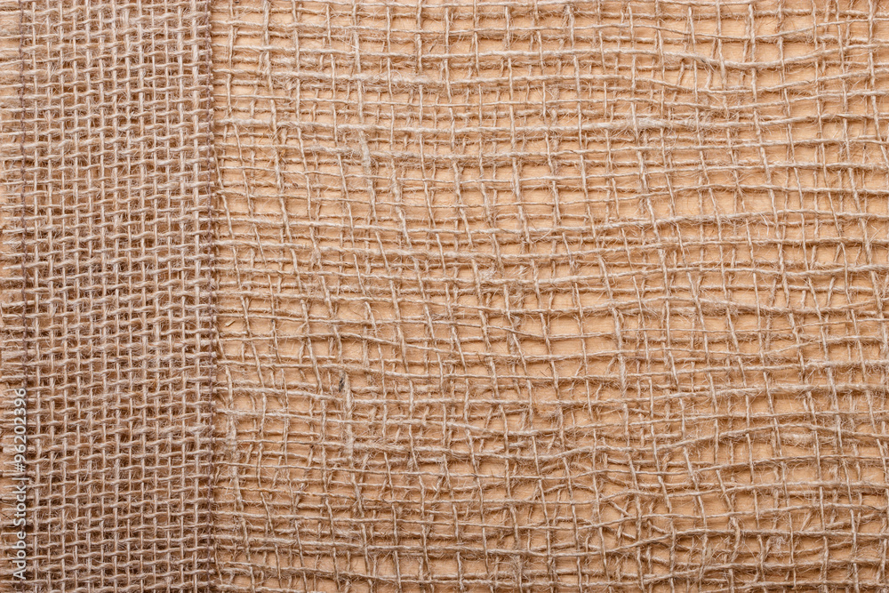 Jute ribbon on burlap cloth background Jute ribbon on burlap cloth background