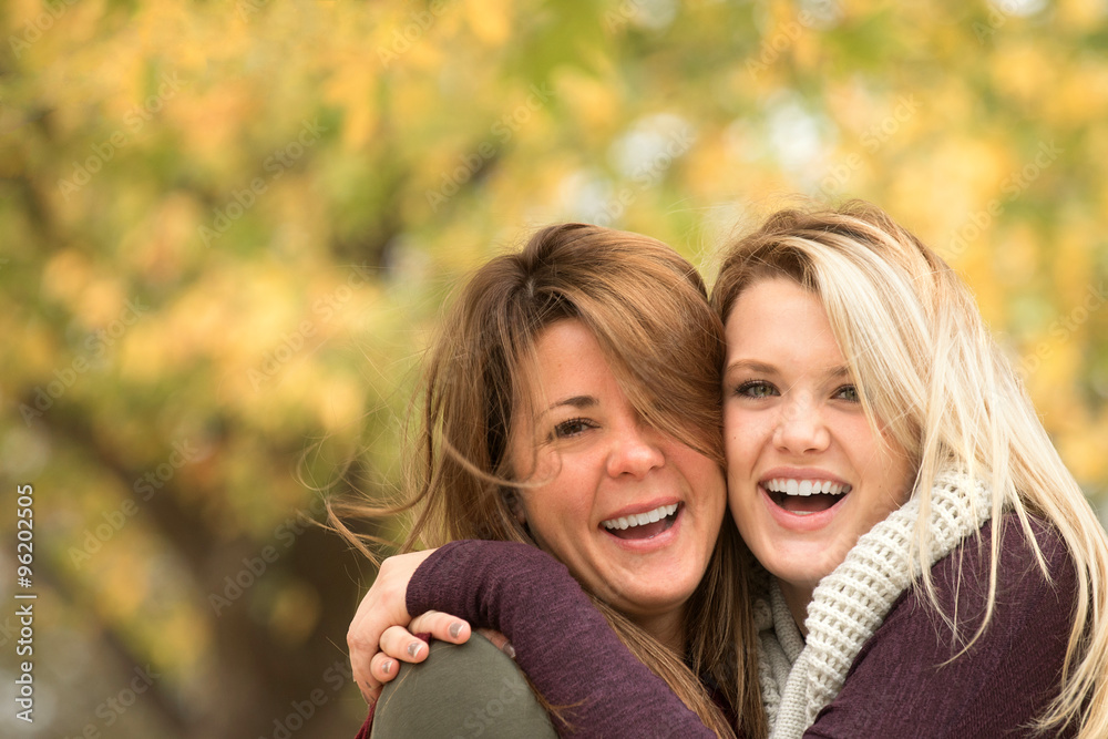 Mother and daughter hugging and laughing.