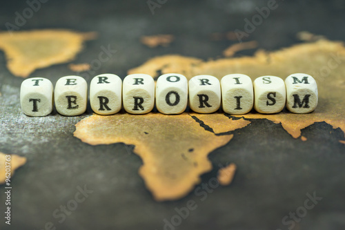 Wooden blocks with the text, TERRORISM, on the background of world map photo