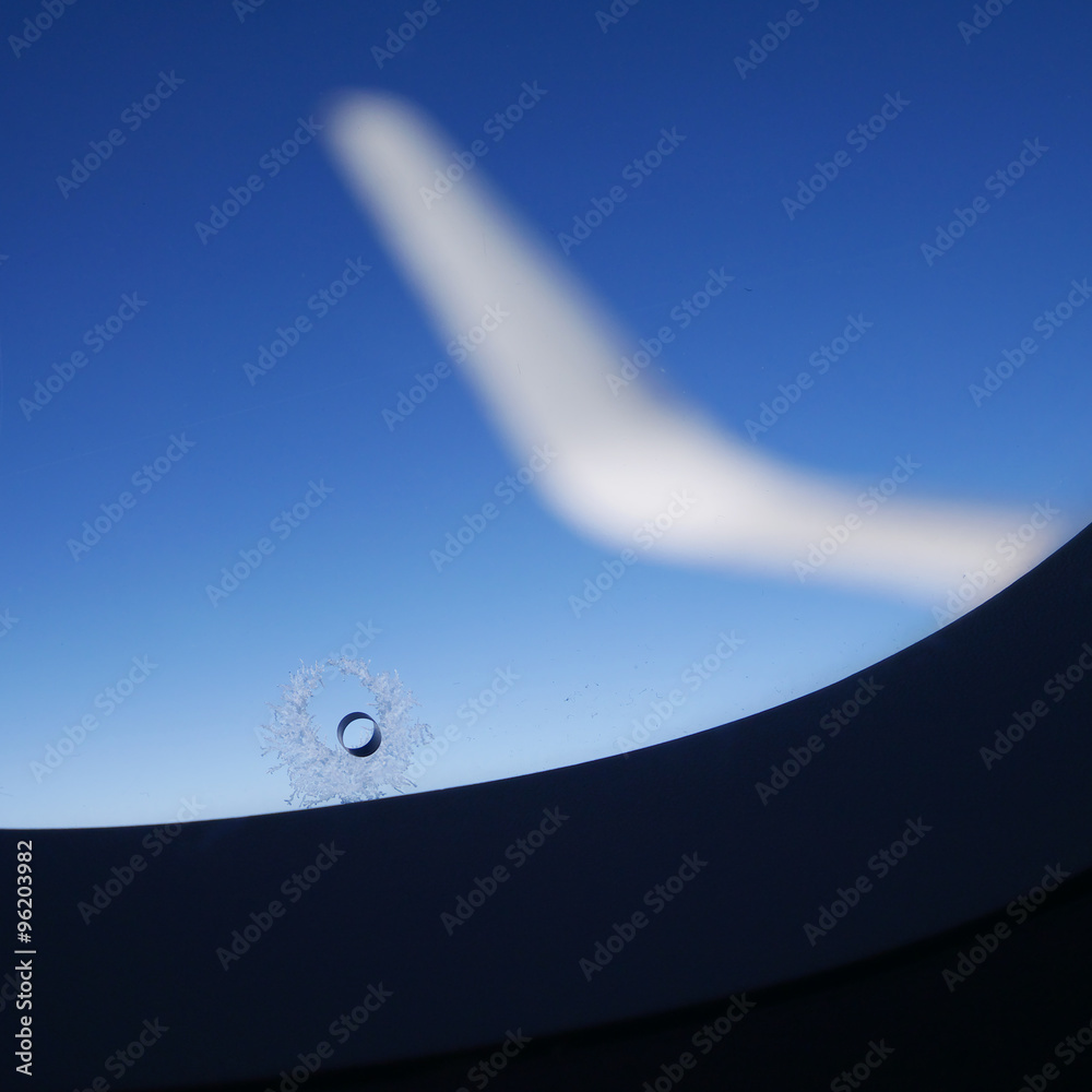 Fototapeta premium The little hole in airplane window with a ring of ice crystals. (2)