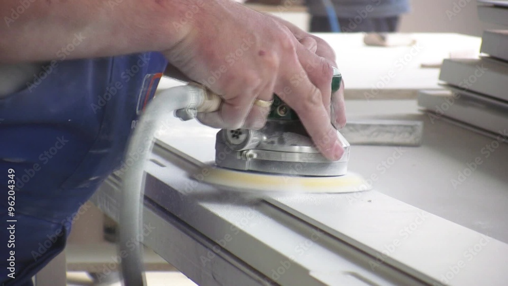 Worker using a power sander to smooth part of the doors frame.
Worker using a power sander to smooth part of the doors frame.