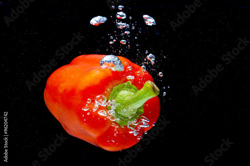 Fresh Red Bell Pepper Splash in Water on Black Background.