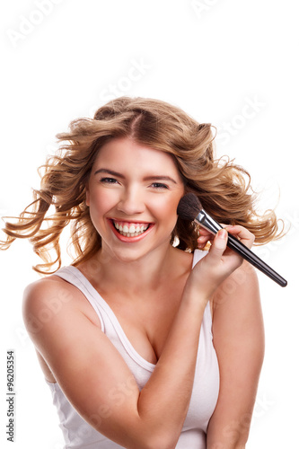 Girl with curly hair straightens makeup brush.