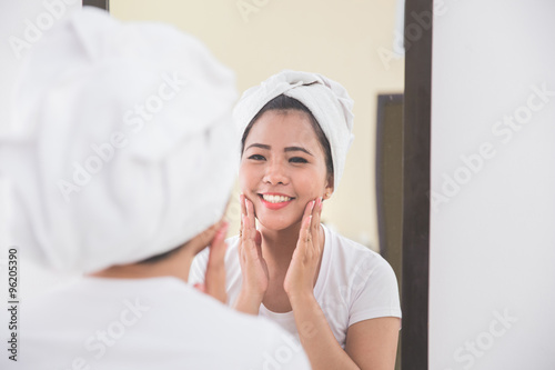 Woman applying skincare lotion into her face