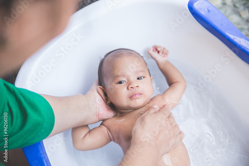 Bathing baby in a tub outdoor