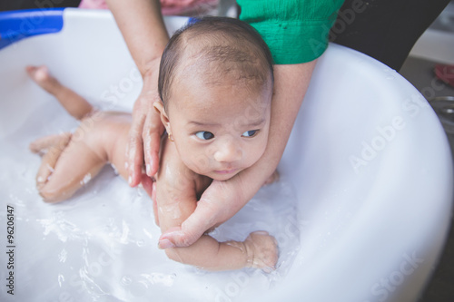 Bathing baby in a tub outdoor