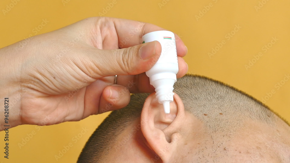 Pouring medical drops in ears for healing an otitis. Otitis is a