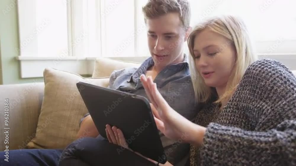 Cute couple using tablet together on couch Cute couple using tablet together on couch