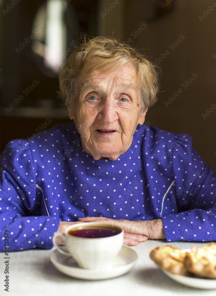 Portrait of an old granny drinks black tea at the table. Portrait of an old granny drinks black tea at the table.