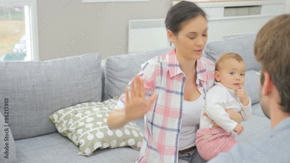 Man and woman arguing in front of baby