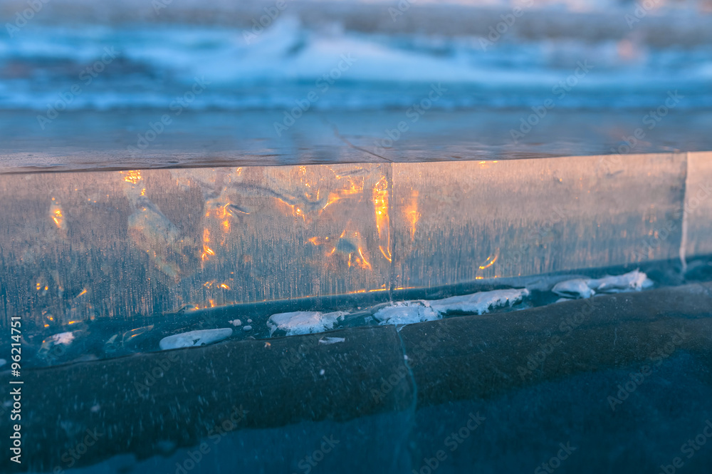 slice of ice on the frozen lake at sunset