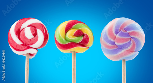 three striped lollipops isolated on blue background