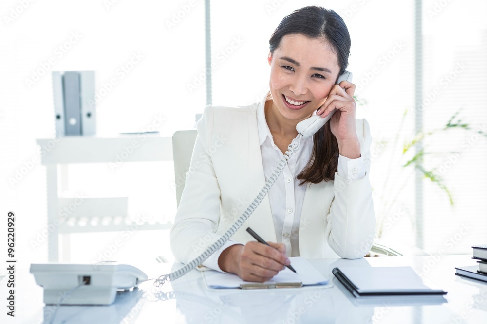 Smiling businesswoman using her telephone Smiling businesswoman using her telephone