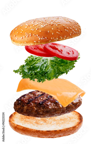 delicious burger with flying falling ingredients on white background