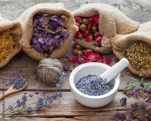 Fototapeta Naklejka Na Ścianę i Meble -  Healing herbs in hessian bags and mortar with dry lavender, herb