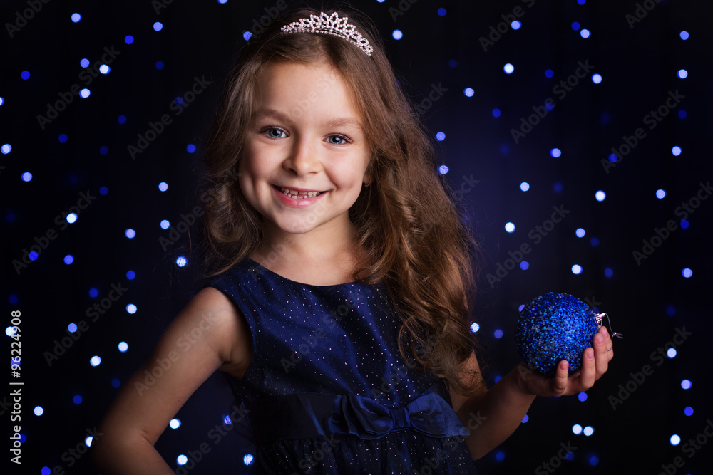 Naklejka premium Pretty girl is holding blue christmas ball