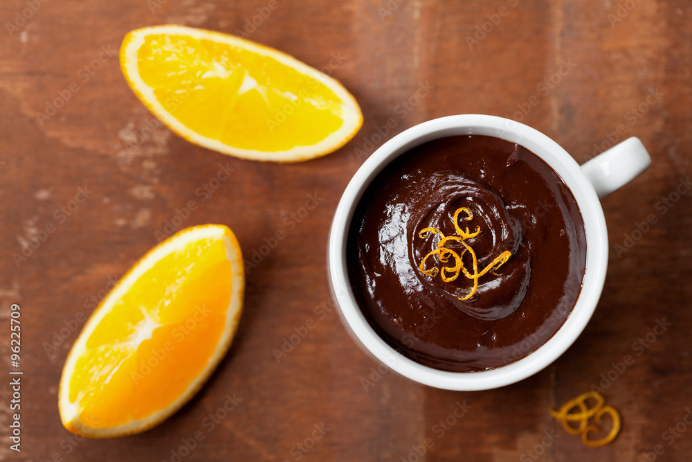 Delicious dessert from dark chocolate mousse with orange slice decorated citrus peel on rustic table, top view Delicious dessert from dark chocolate mousse with orange slice decorated citrus peel on rustic table, top view