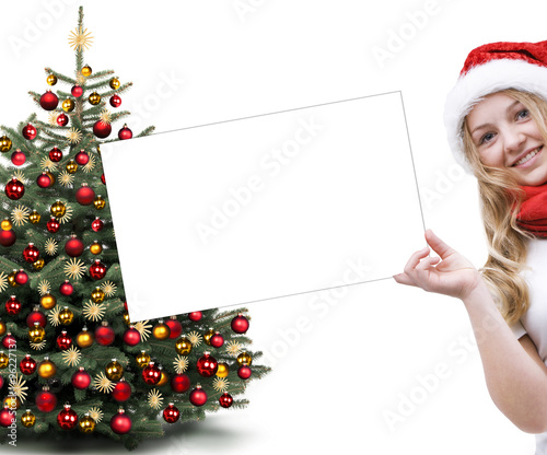 Mädchen mit Weihnachtsmütze und Christbaum