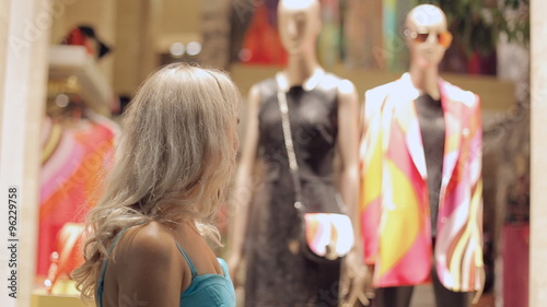 Woman looks admiringly at the windows of boutiques in Milan photo