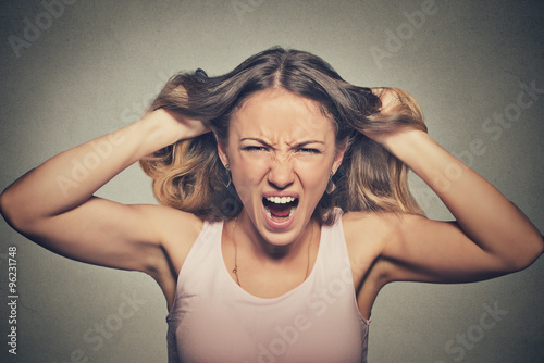 frustrated angry woman pulling hair out yelling screaming photo