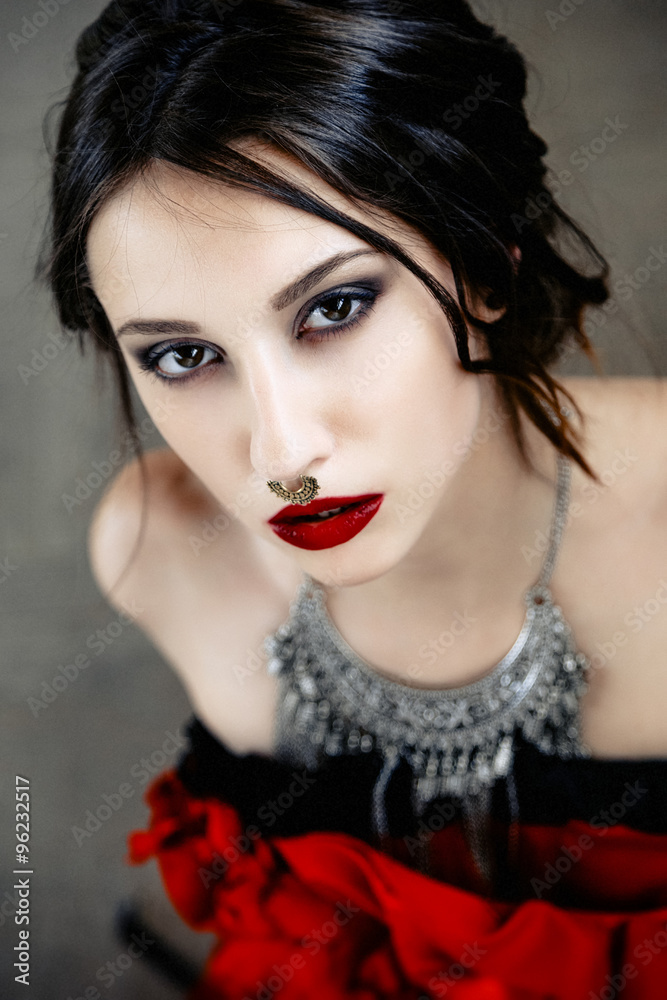 Fototapeta premium Beautiful woman with cute face bright make up red lips and piercing on nose