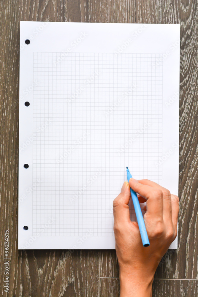Woman hand writing on empty math book Woman hand writing on empty math book
