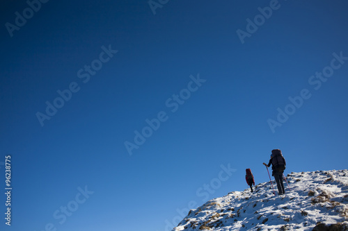 Mountaineers climb the snowy slope.