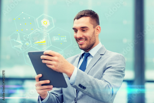 smiling businessman with tablet pc outdoors