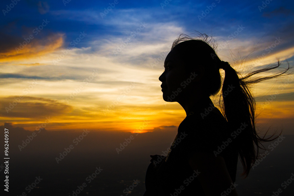 Silhouette of a woman with evening sky.