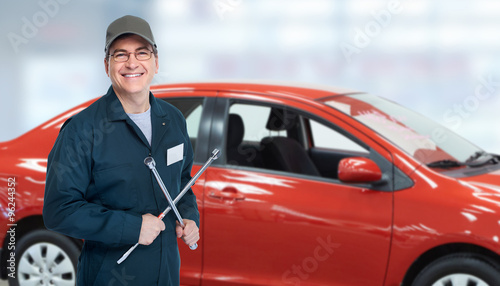 Auto mechanic with tire wrench in garage.