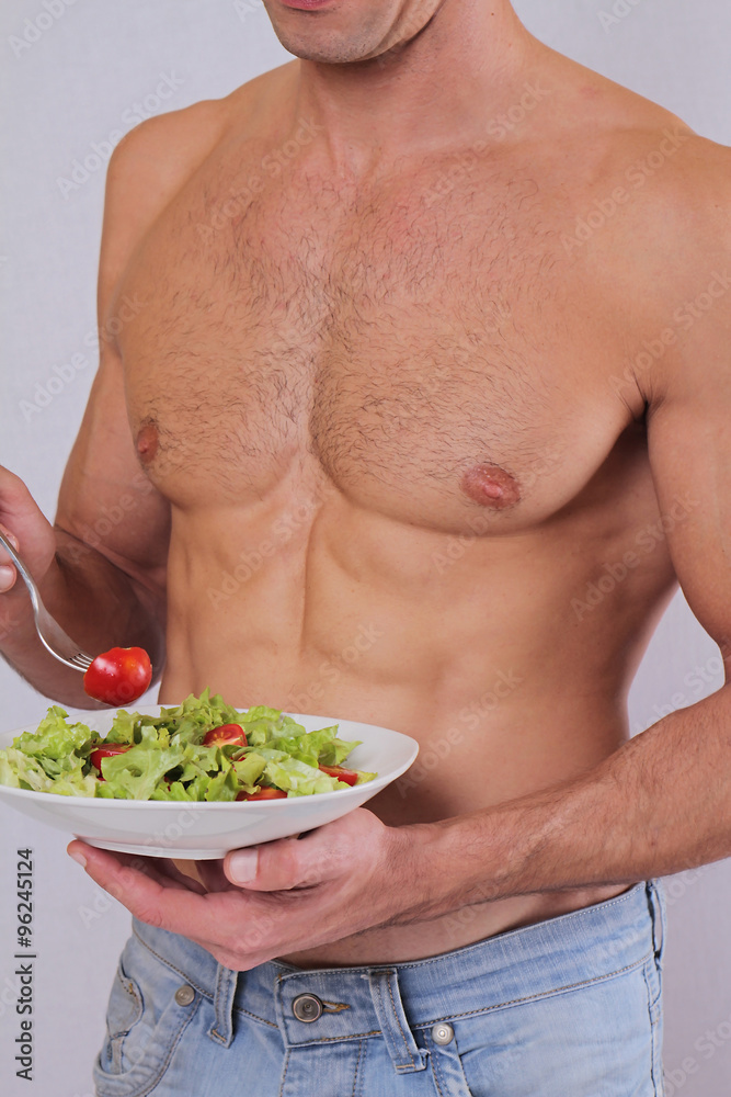 Close up of muscular man eating salad. Healthy life style, vegetarian bodybuilding concept. Close up of muscular man eating salad. Healthy life style, vegetarian bodybuilding concept.